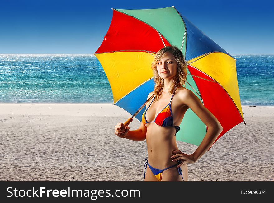 blond girl in bikini holding a beach umbrella on the beach. blond girl in bikini holding a beach umbrella on the beach