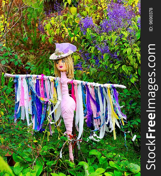 Colorful female scarecrow in a garden