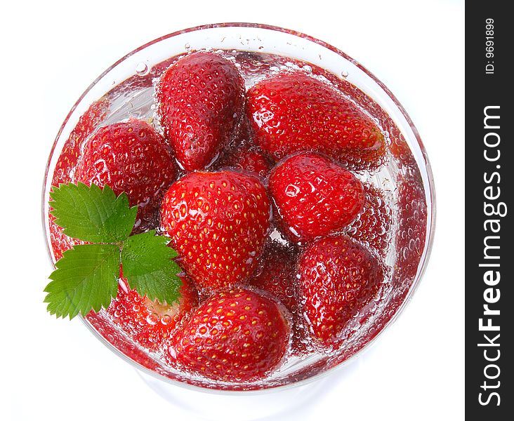 Red strawberries with green leaf in glass of water