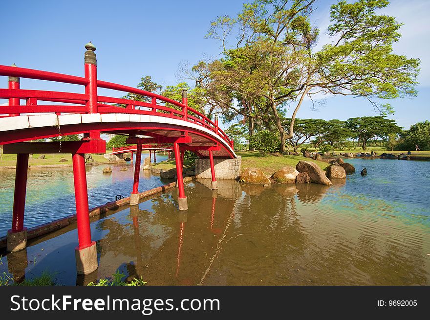 A red bridge in a chinese nature park. A red bridge in a chinese nature park.
