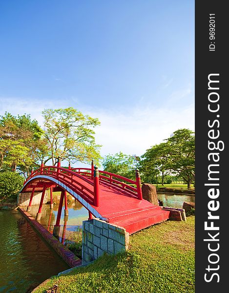 A red bridge panning across the lake in an ancient Chinese garden. A red bridge panning across the lake in an ancient Chinese garden.