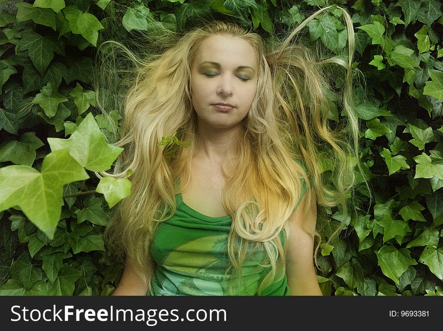 Blonde with long hair sleeping in leaves. Blonde with long hair sleeping in leaves