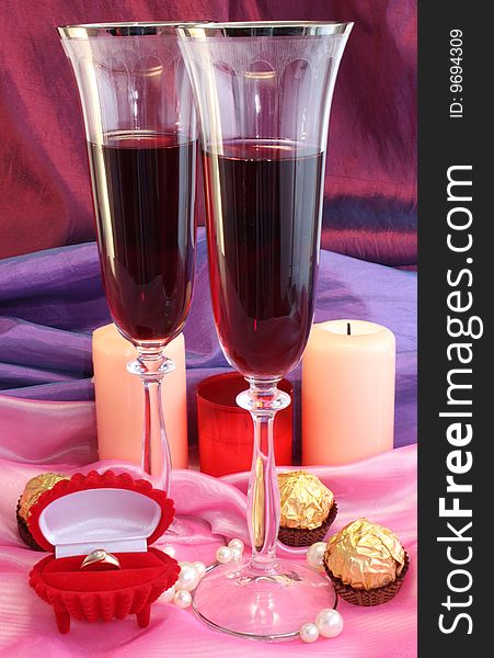 Two glasses with wine, a ring and chocolate