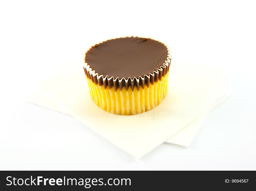 Delicious looking cup cake resting on two white napkins on a plain background