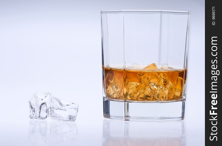 A glass of whisky with ice. A glass of whisky with ice