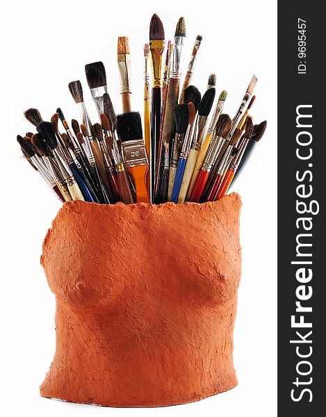 Collection of brushes in a ceramic vase as a female torso. Collection of brushes in a ceramic vase as a female torso