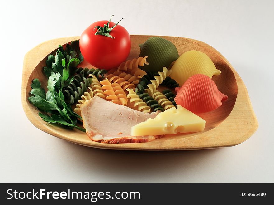 Tomato, pasta, ham, cheese on woodden plate. Tomato, pasta, ham, cheese on woodden plate