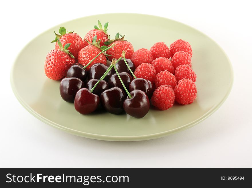 Red fruits on light plate