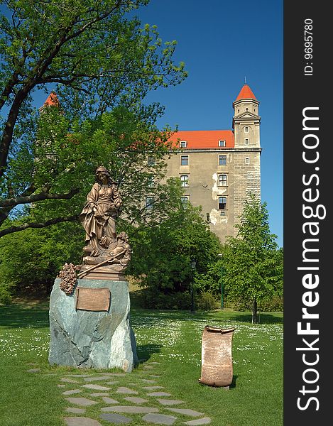 Bratislava castle in background, woman sculpture in foreground, park