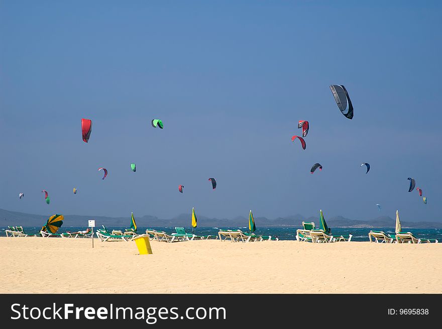 A lot of colorful kite-surfers on the beach