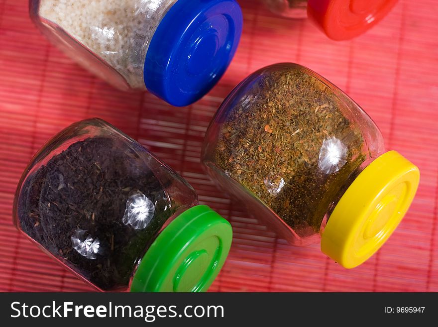 Four glass jars with spices and color covers