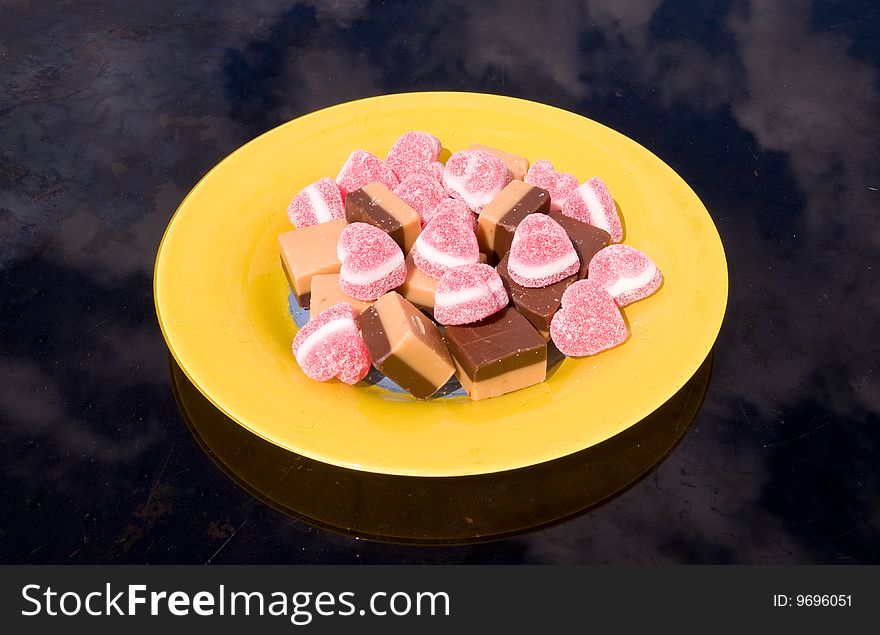 Sweets and marmalade on the yellow plate