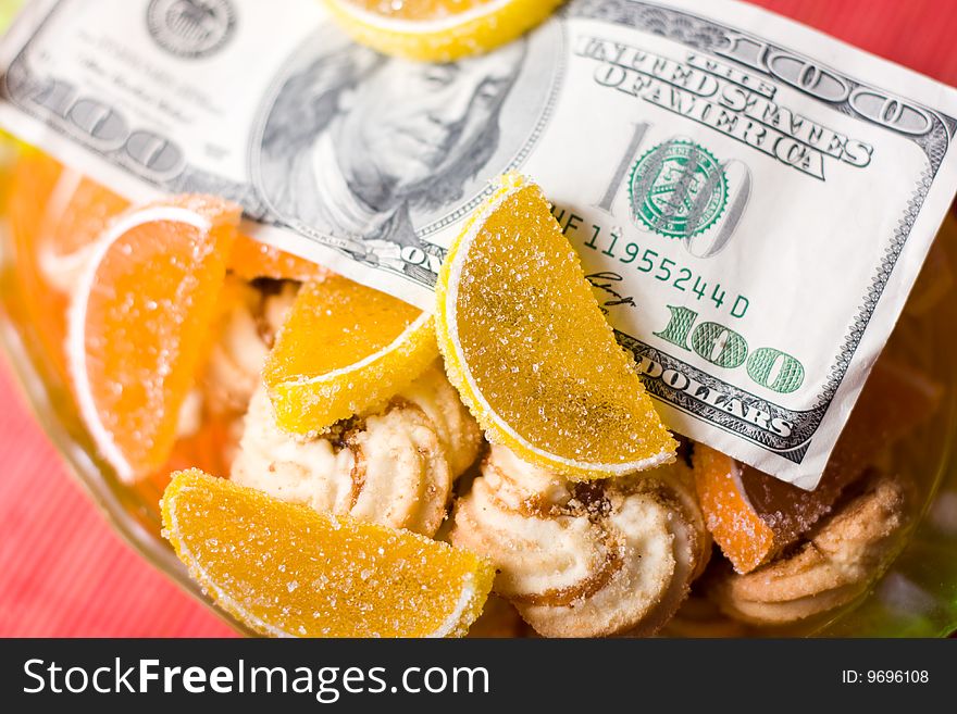 Paper money in bowl  with fruit jelly and sweet cookies. Paper money in bowl  with fruit jelly and sweet cookies