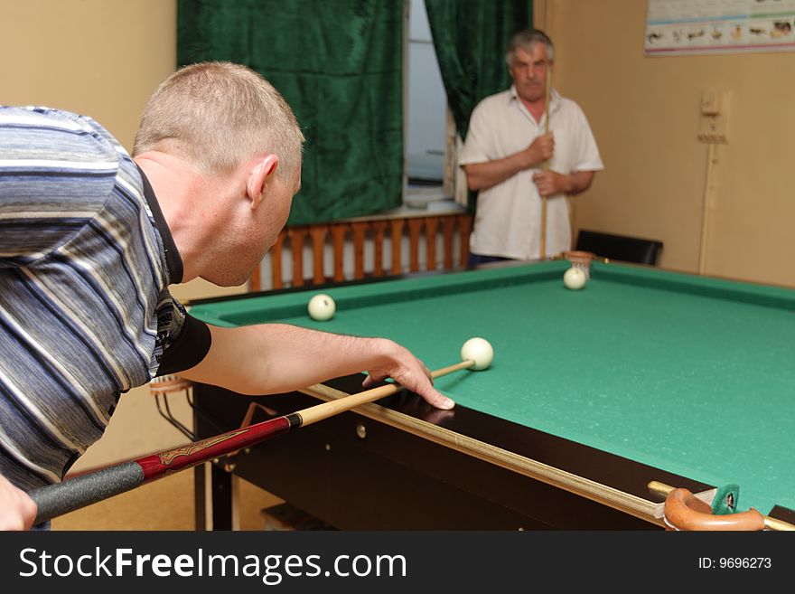 Two men plays in a billiards game