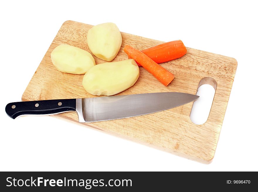 Knife potato and carrots on a wooden board