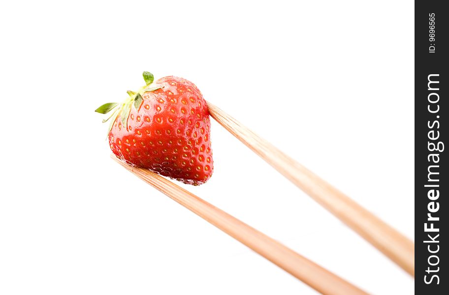 Strawberry close-up held with chop sticks