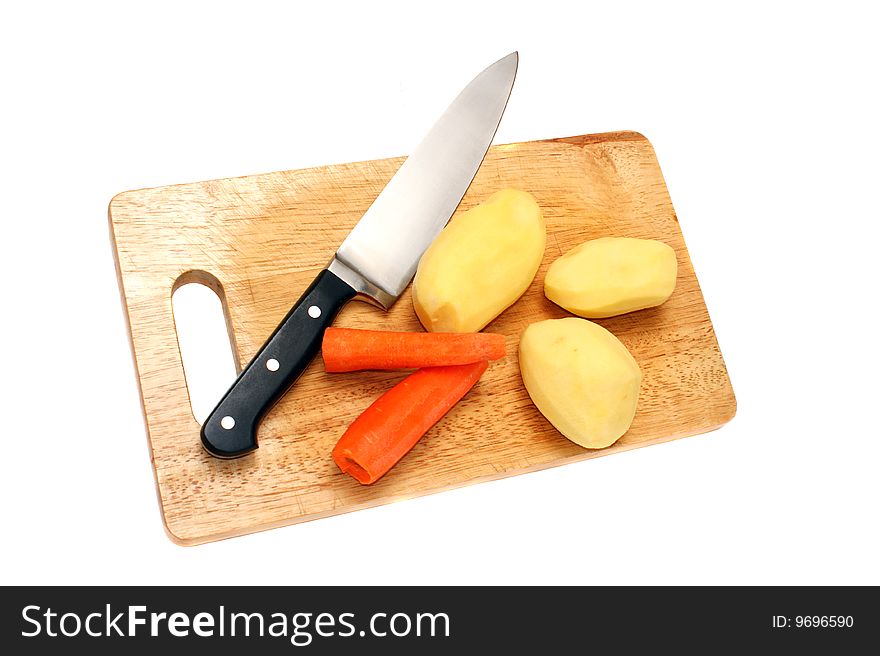Knife potato and carrots on a wooden board