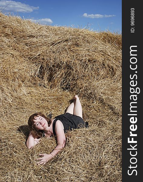 The beautiful woman is relax on the hay. The beautiful woman is relax on the hay