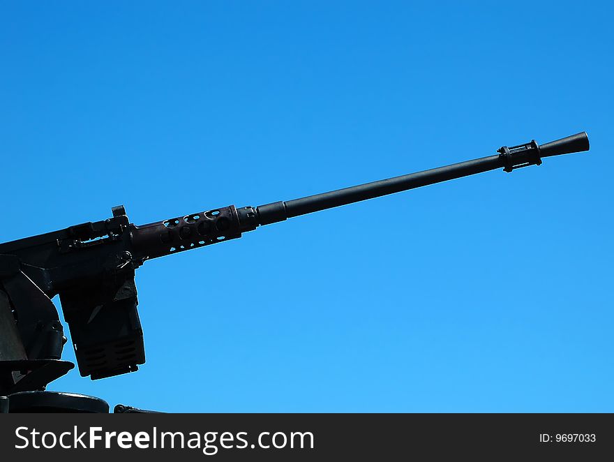 Machine gun on the combat vehicle opposite blue sky. Machine gun on the combat vehicle opposite blue sky