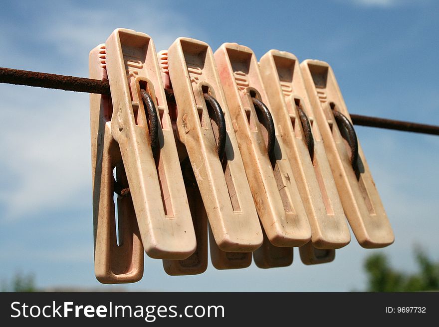 Clothes-pins on a rope on a background sky