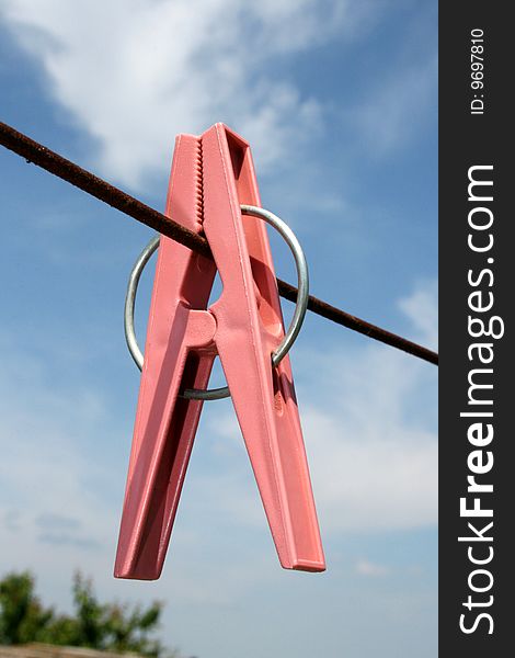 Clothes-pin on a rope on a background sky