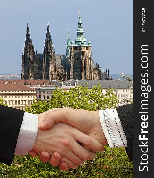 Businessmen shaking hands with Prague Castle