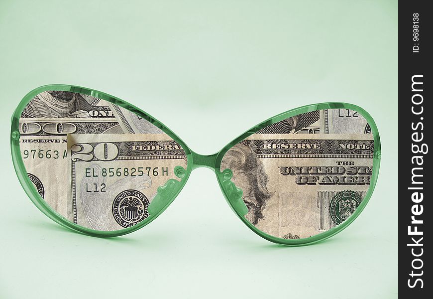 Sunglasses with money instead of glasses on green background. Sunglasses with money instead of glasses on green background