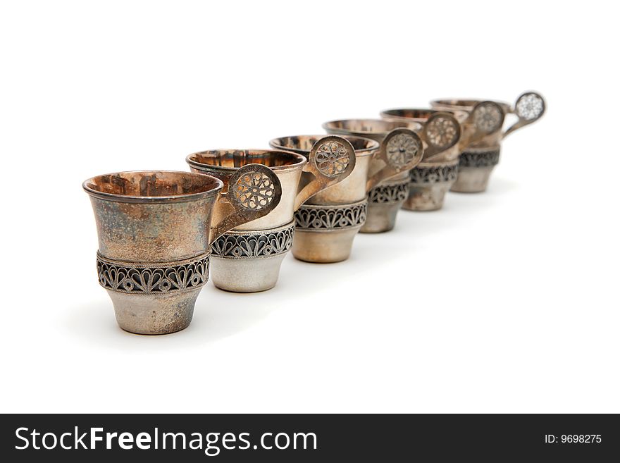 Row of six vintage silver cups isolated
