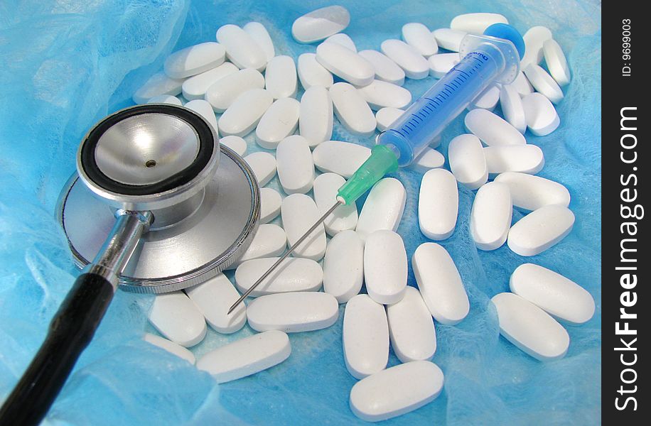 Stethoscope and pills in isolated on blue. Stethoscope and pills in isolated on blue