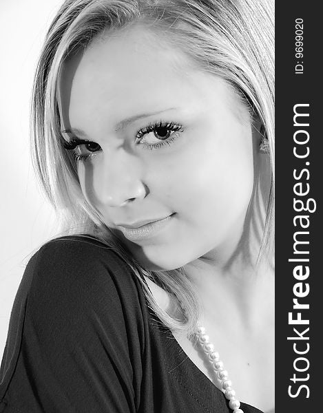 Young female model head shot edited to black and white. with a shy but confident grin on her face shugging up her shoulder. Young female model head shot edited to black and white. with a shy but confident grin on her face shugging up her shoulder.