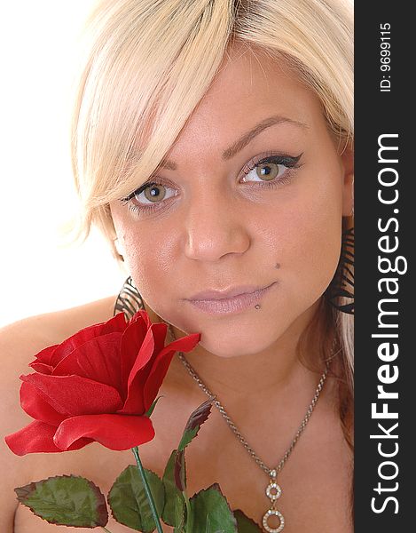 Very lovely young blond girl with an red rose in her hand and a diamond necklace around the neck in a portrait shot in close up. Very lovely young blond girl with an red rose in her hand and a diamond necklace around the neck in a portrait shot in close up.