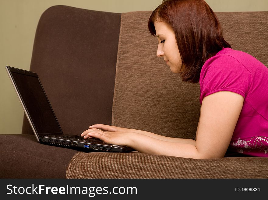 Woman with laptop on sofa