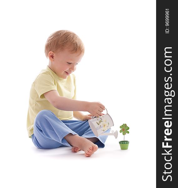 Portrait of adorable happy boy using watering-pot want to water artificial wooden flower. Portrait of adorable happy boy using watering-pot want to water artificial wooden flower