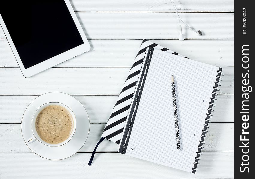 White Tablet Computer Beside White Notebook