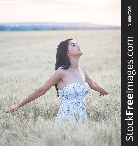 Beautiful Woman In Summer In Wheat Field At Sunset