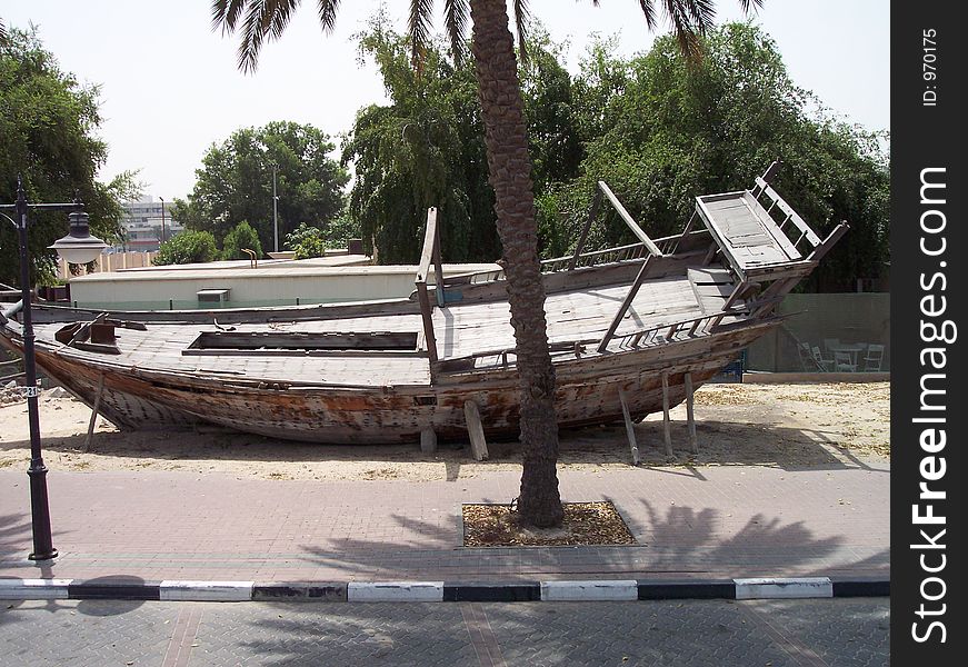 This is an old wooden dhow on the side of the road in Dubai. Dhows are used for transporting products. Dubai is in the United Arab Emirates.