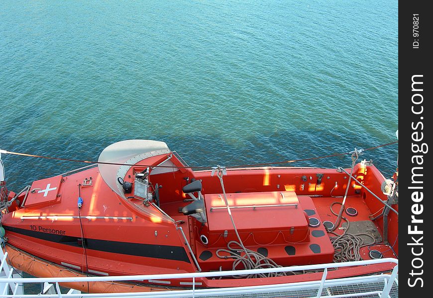 Red lifeboat on cruise ship.