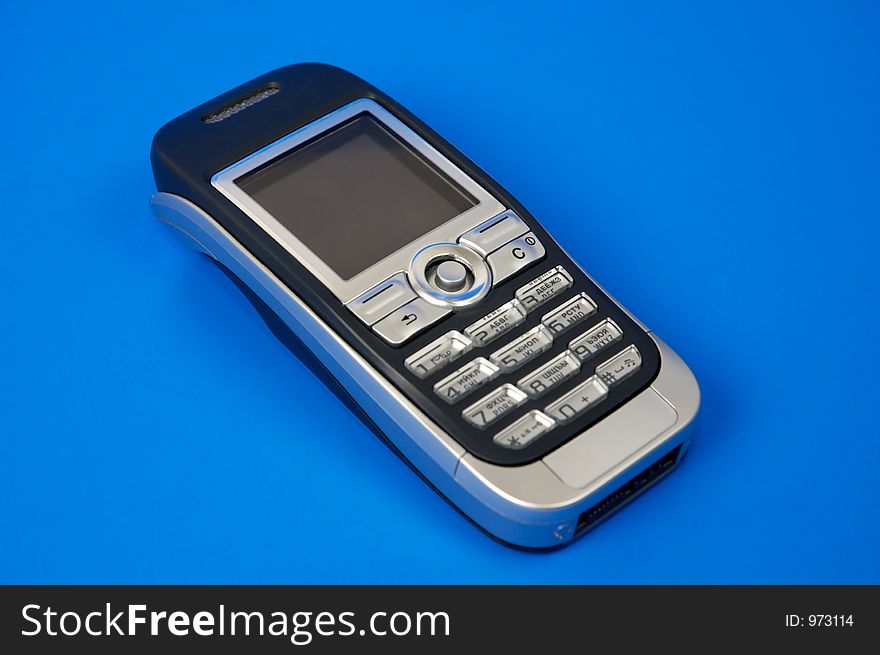Gray modern cellphone isolated on blue background close-up