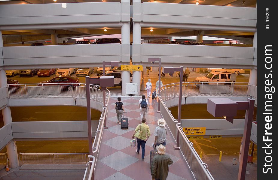 Passengers with luggage rushing through a modern airport structure. Passengers with luggage rushing through a modern airport structure