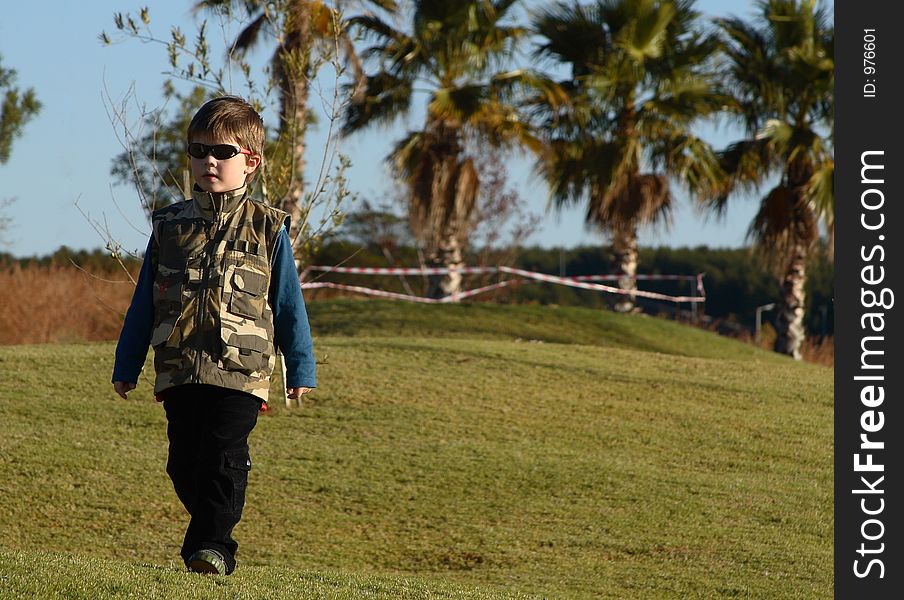 Young boy with sunglasses and camouflage jacket