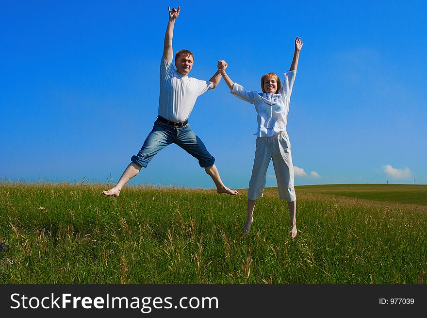 Couple jumping in field