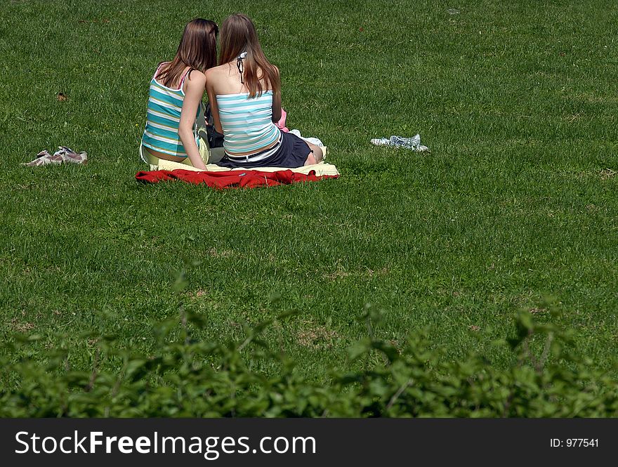 Two young girls have a rest in park