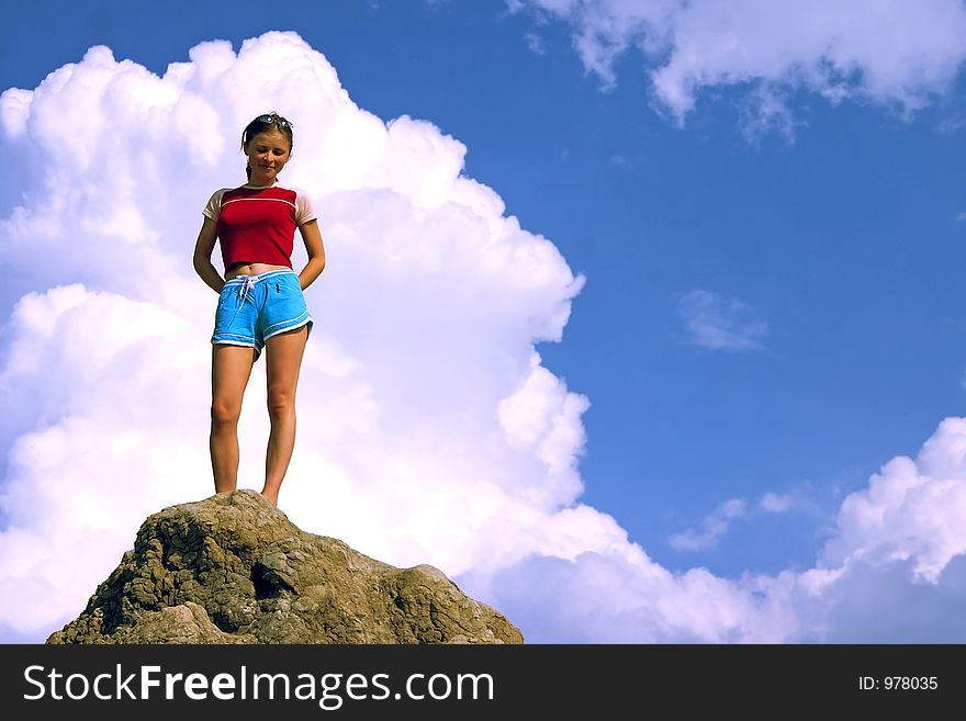 Girl in the top of the hill over the blue sky. Girl in the top of the hill over the blue sky