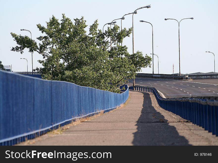 View at city sidewalk near road whit curve and lamps