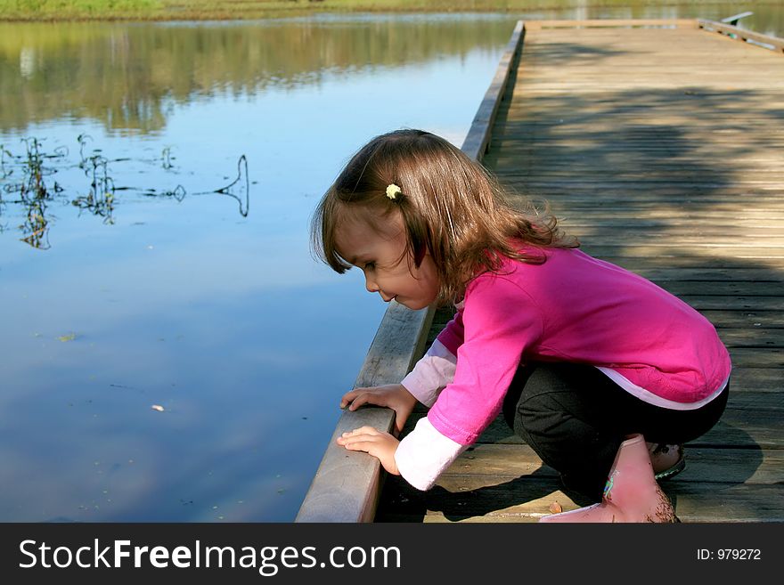 Small child peeking into the water. Small child peeking into the water