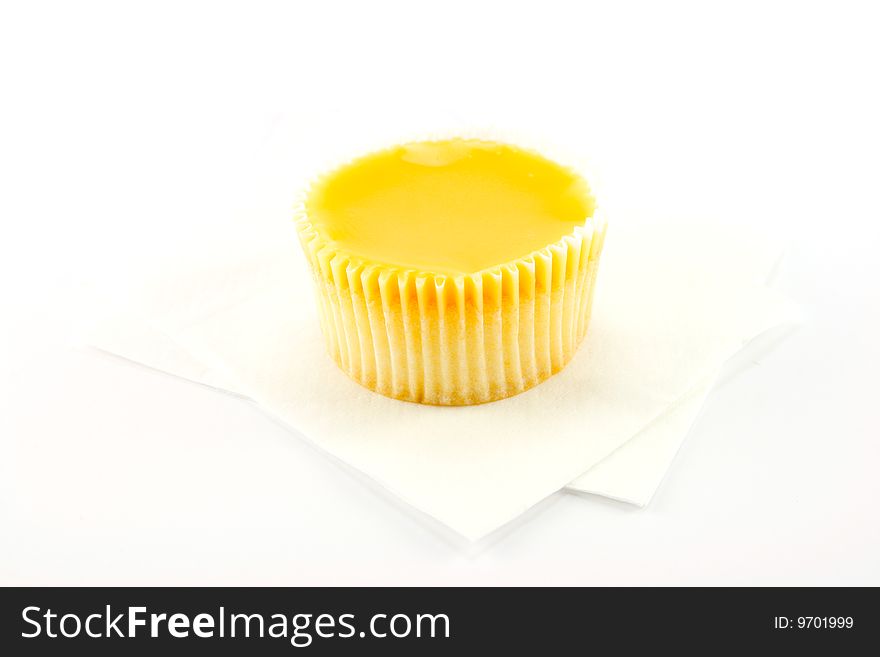 Delicious looking cup cake resting on two white napkins on a plain background