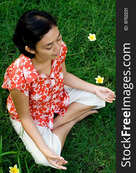 Pretty asian young woman meditating in a green environment. Pretty asian young woman meditating in a green environment