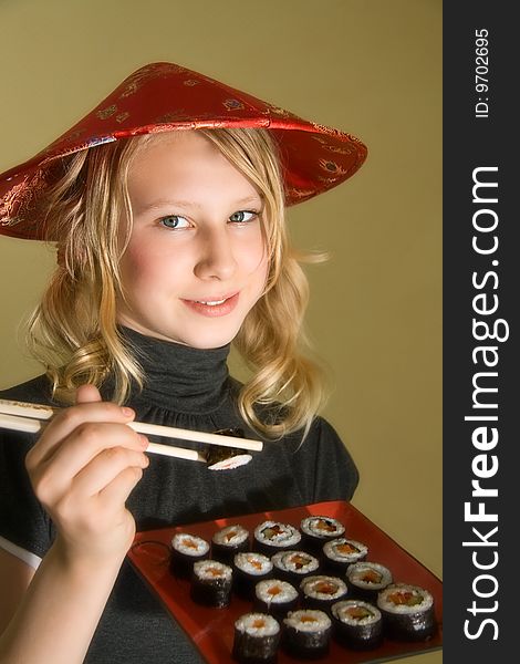 A 13 years old girl with a sushi platter and chopsticks. A 13 years old girl with a sushi platter and chopsticks