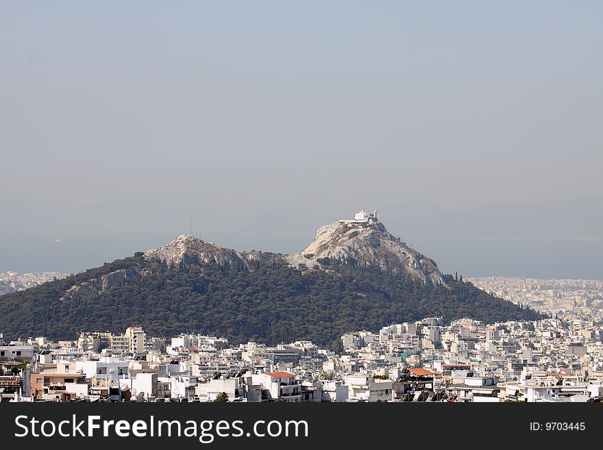 A distant view of the Lycabettus Hill in downtown Athens, Greece. A distant view of the Lycabettus Hill in downtown Athens, Greece