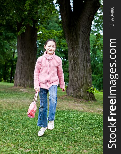 Girl jumps on a green grass against trees. Girl jumps on a green grass against trees
